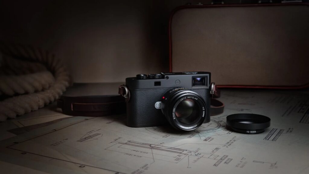 Leica Summicron-M 66 f/2 mounted on an M camera beside technical drawings