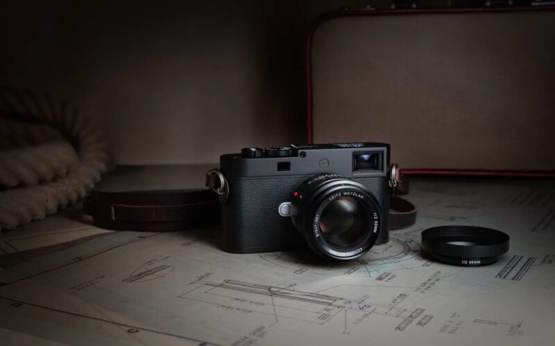 Leica Summicron-M 66 f/2 mounted on an M camera beside technical drawings