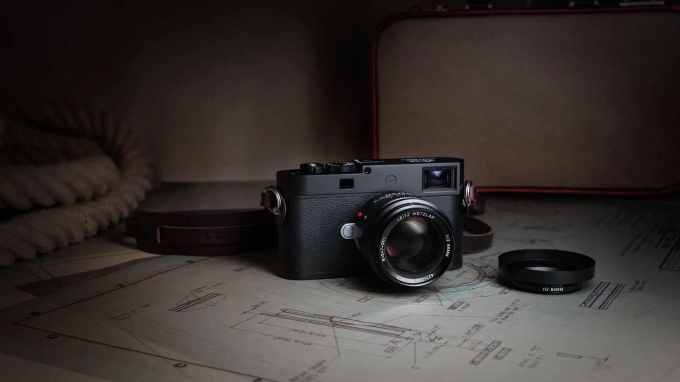 Leica Summicron-M 66 f/2 mounted on an M camera beside technical drawings