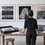 Photographer preparing framed prints and a portfolio for a juried gallery show
