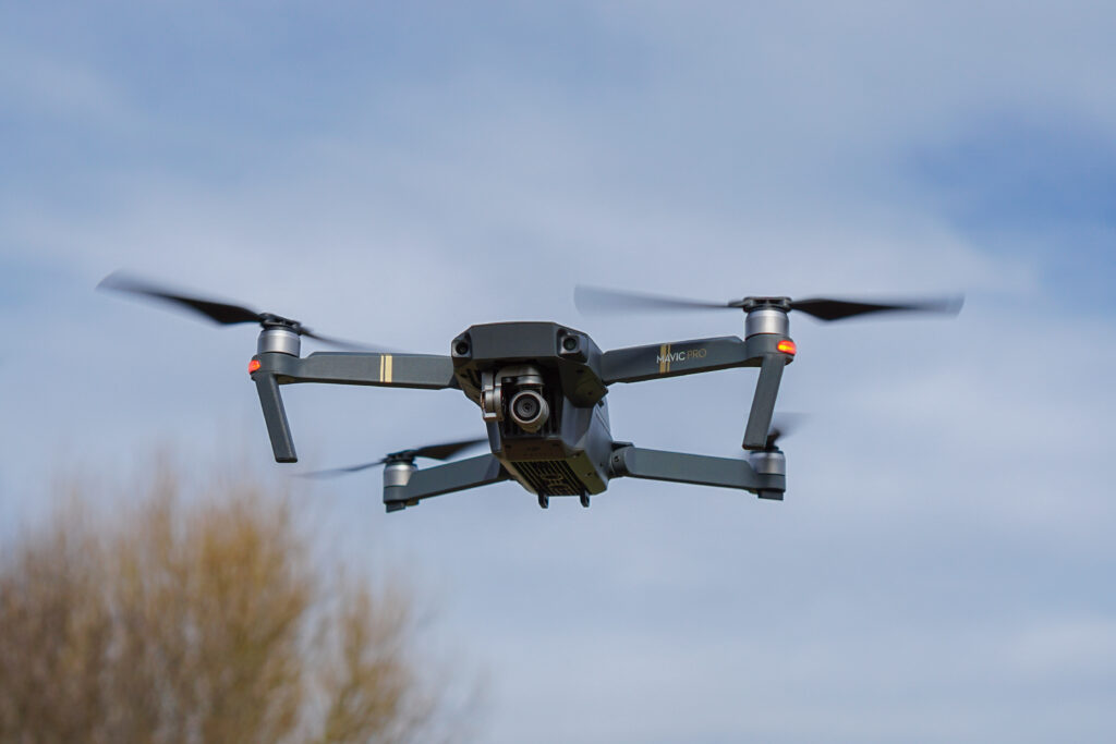 DJI Mavic Pro quadcopter in flight against a blue-gray sky.