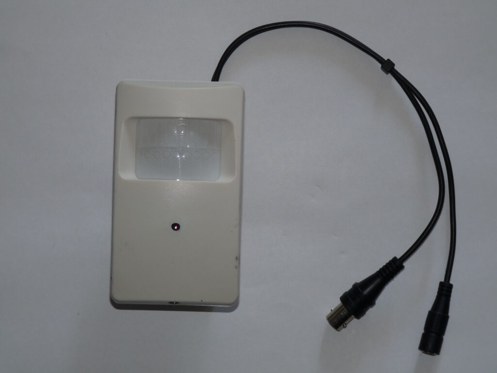 Compact rectangular security video camera with its attached connection cable.