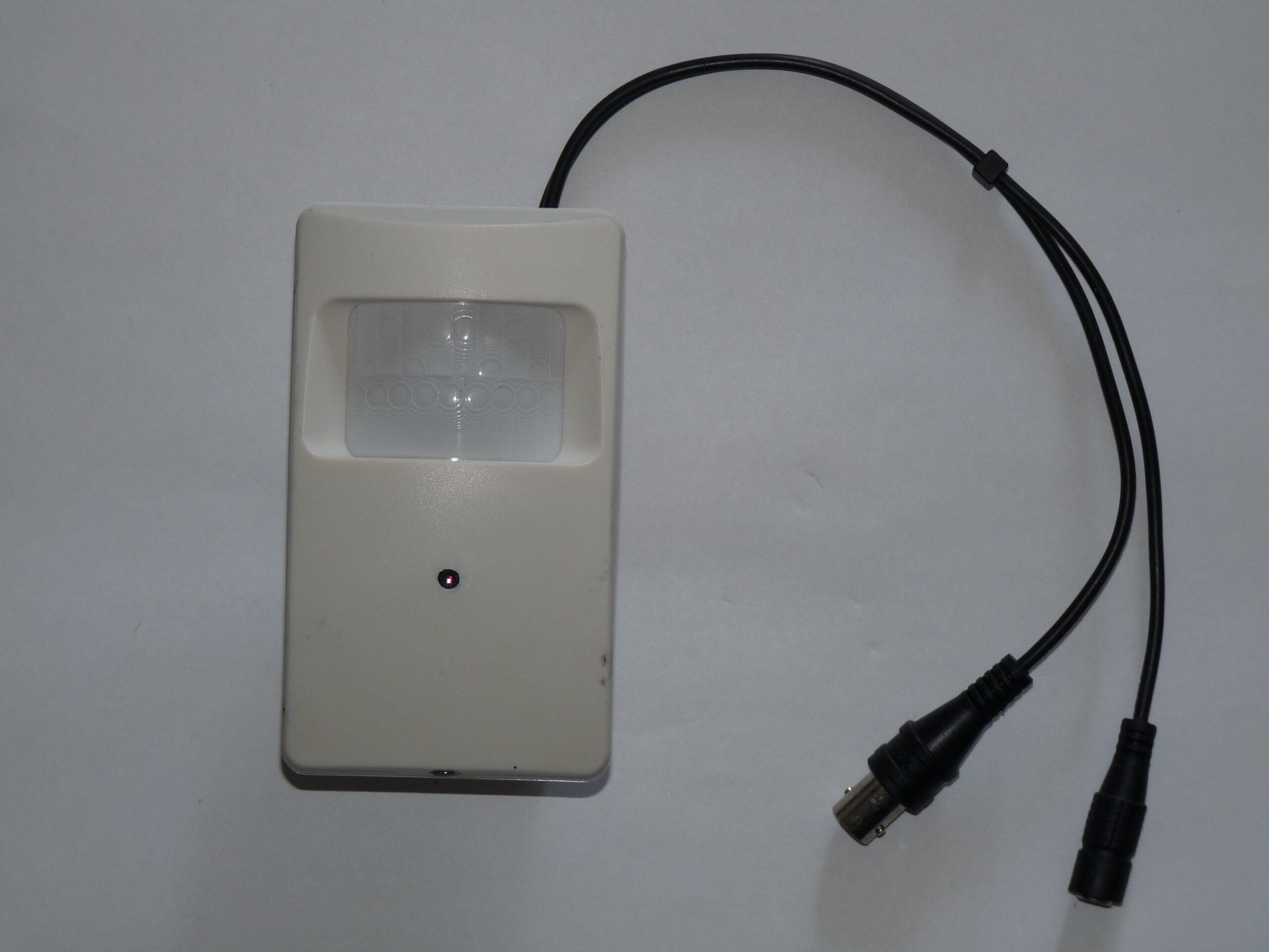 Compact rectangular security video camera with its attached connection cable.